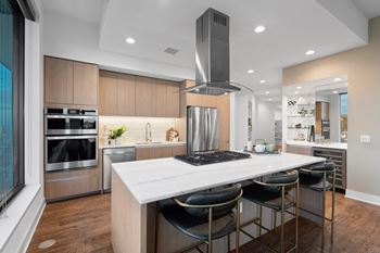 a kitchen with a stainless steel appliances and wooden cabinets  at Stanza Little Italy, San Diego